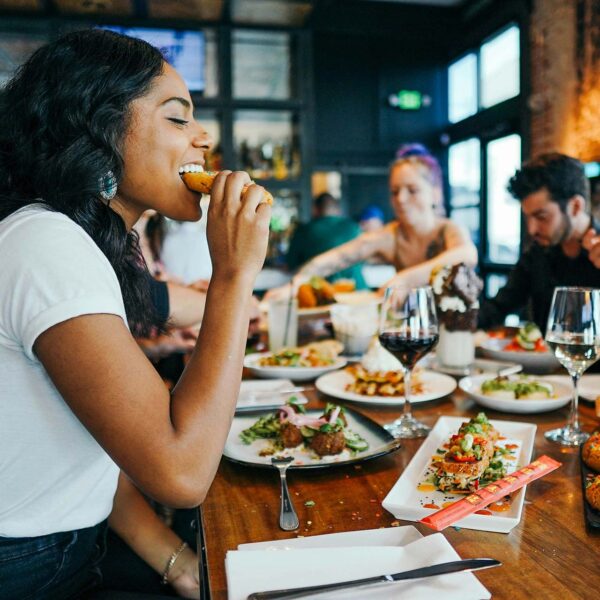 Friends eating together at restaurant with eclectic cuisine.