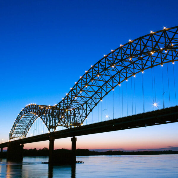 Metal bridge over river at dusk.