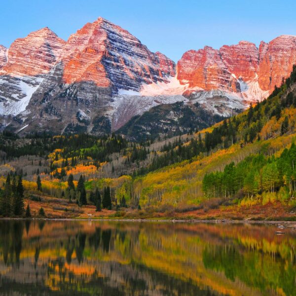 Maroon Bells mountains with autumnal trees and reflective lake.