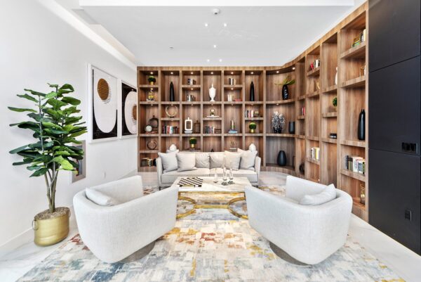 Lounge with plush seating, framed artwork, and shelves with decor.