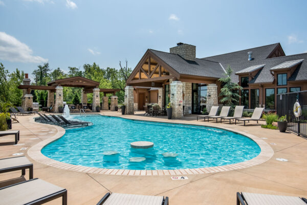 Pool area with lounge chairs, gazebos, and clubhouse.