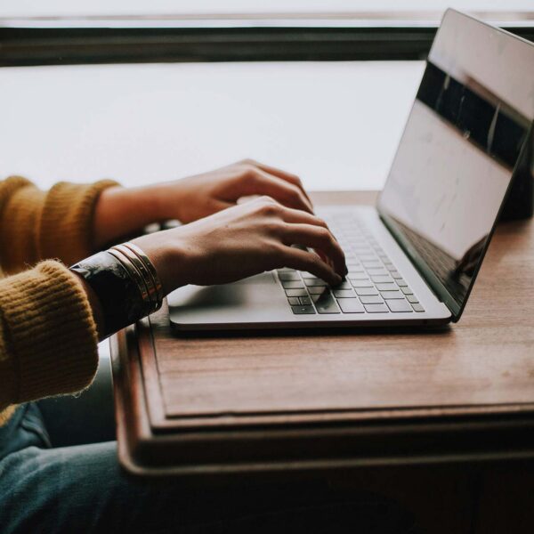 Person typing on laptop computer at desk.