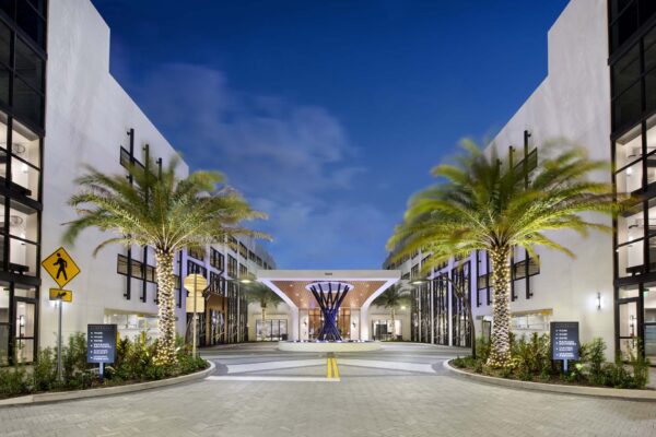 Sanctuary Doral apartments entrance driveway with tall palm trees.