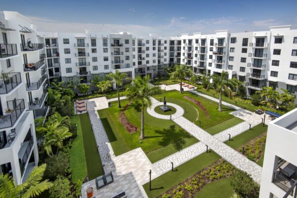 Courtyard with paver walkways, lush lawns, and palm trees.