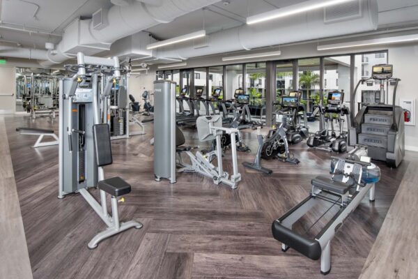 Fitness center with wood style floor, cardio machines, and weight equipment.