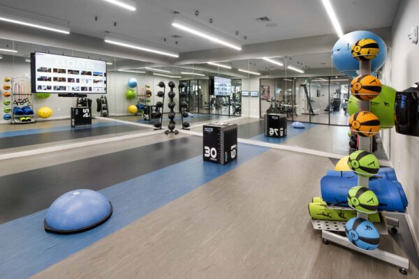 Fitness center with wall mounted TV and calisthenics equipment.