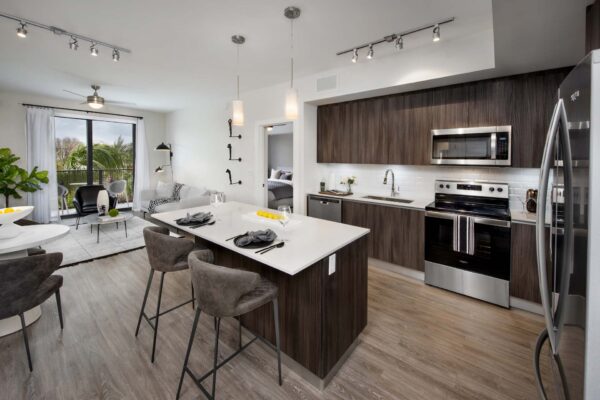 Kitchen with wood style floor and cabinets, stone counters, and stainless steel appliances.