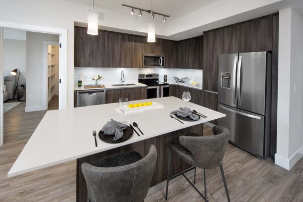 Kitchen with wood style floor and cabinets, stone counters, and stainless steel appliances.