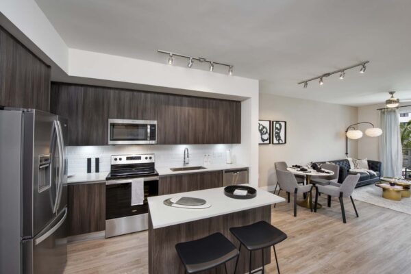 Kitchen with wood style floor and cabinets, stone counters, and stainless steel appliances.