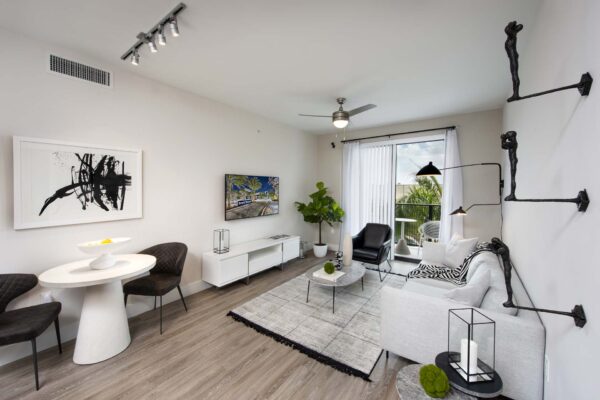 Living room with wood style floors, modern furniture, and and door to balcony.
