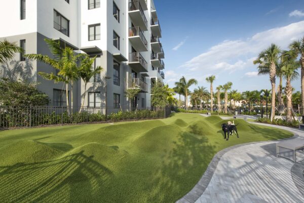 Dog park with lush green lawns and paver walkways.