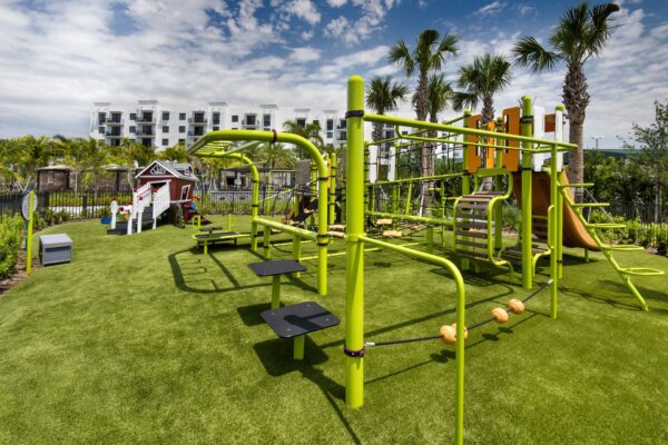 Playground with gym equipment and lush green lawns.
