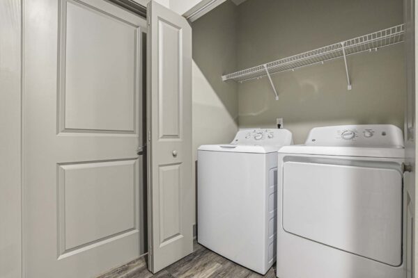 Laundry closet with washer dryer and wire shelves.