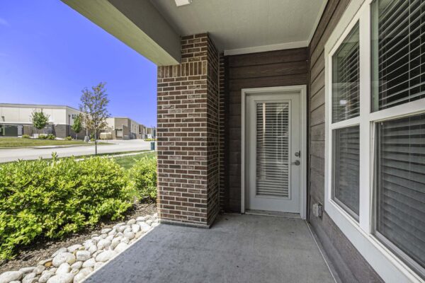Apartment patio overlooking landscaping.