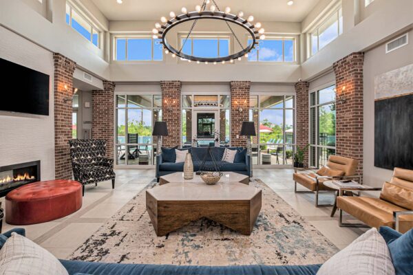 Lobby with pattern rug, plush seating, fireplace, and wall mounted TV.