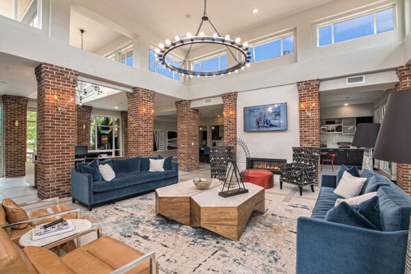 Lobby with pattern rug, plush seating, fireplace, and wall mounted TV.