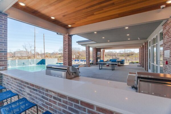 Outdoor lounge with dining tables and built in barbeque grills.