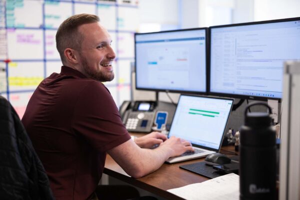 Avanti employee laughing while working at computer desk.