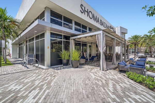 Sanctuary Doral apartments exterior with Shoma Bazaar restaurant patio.