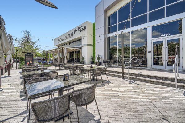 Sanctuary Doral apartments exterior with stone paver patio and dining table.