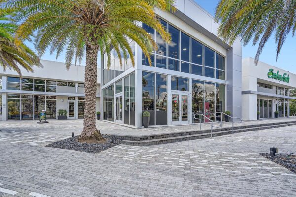 Sanctuary Doral apartments exterior with stone paver walkways and large palm trees.