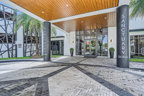 Sanctuary Doral apartments entrance with stone paver walkways and large columns.