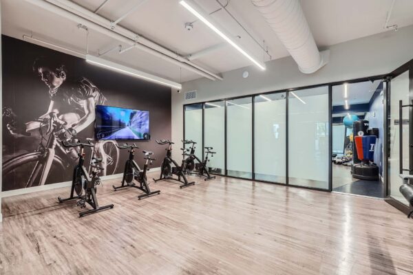 Sanctuary Doral apartments fitness center with spin bikes and TV.