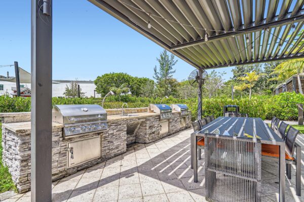 Sanctuary Doral apartments outdoor patio with dining tables and BBQ grills.