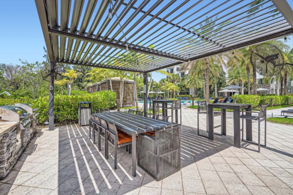Sanctuary Doral apartments outdoor dining area with pergola and dining tables.
