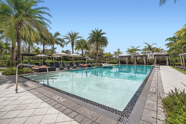 Sanctuary Doral apartments pool area with lounge chairs and umbrellas.