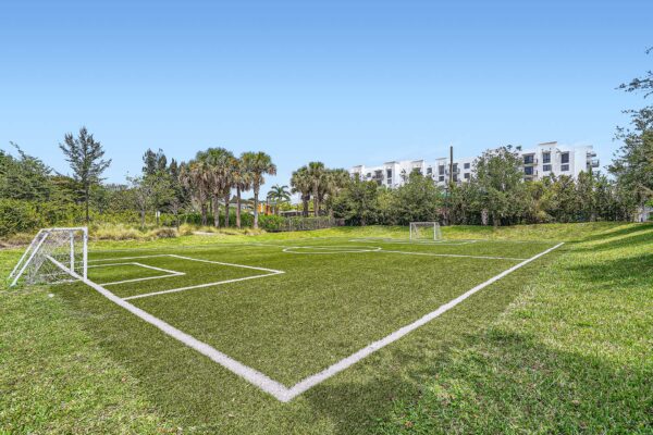 Sanctuary Doral apartments with nearby soccer field and lush grass.