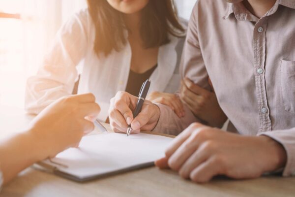 Couple signing leasing contract together.