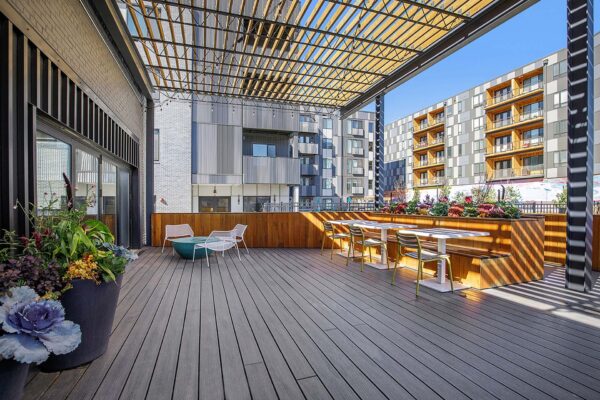 Arte KC clubhouse patio with pergola, outdoor seating, and potted plants.