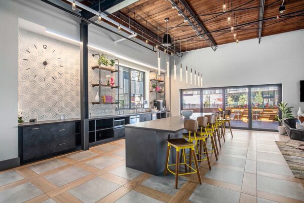 Community kitchen at Arte KC with dining bar area and tall colorful stools.