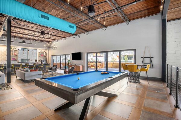 Clubroom at Arte KC apartments with billiards table and comfortable seating.