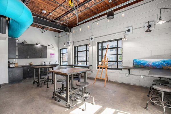 Art studio at Arte KC apartments with craft tables and painting easels.