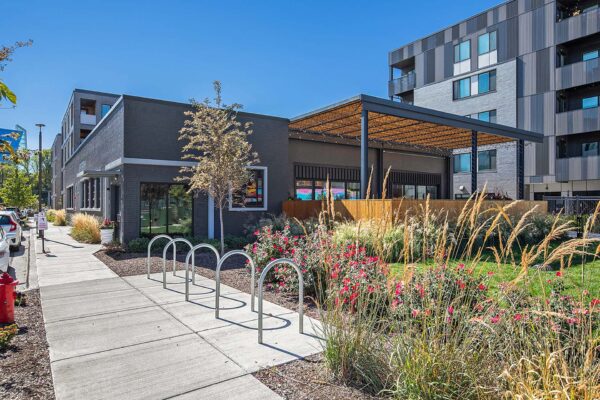 Arte KC apartments clubhouse with lush outdoor landscaping and covered outdoor patio.