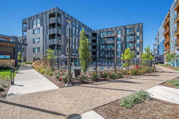 Arte KC apartments outdoor courtyard with stone paver walkways and resort-style pool area.