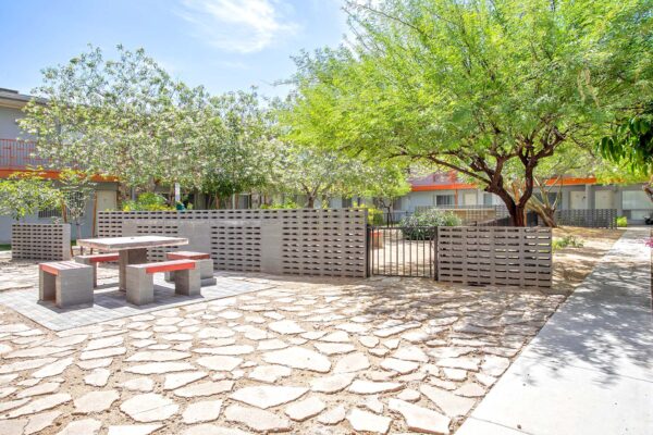 Aura at Midtown apartments courtyard with stone patio and large trees.