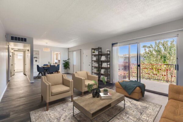 Aura at Midtown apartment living room with plush seating, wood style floors, and large balcony door.