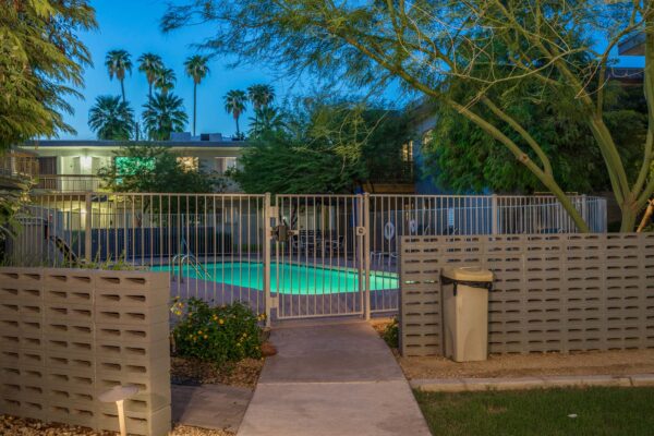 Aura at Midtown apartments pool area with lounge chairs and fence.