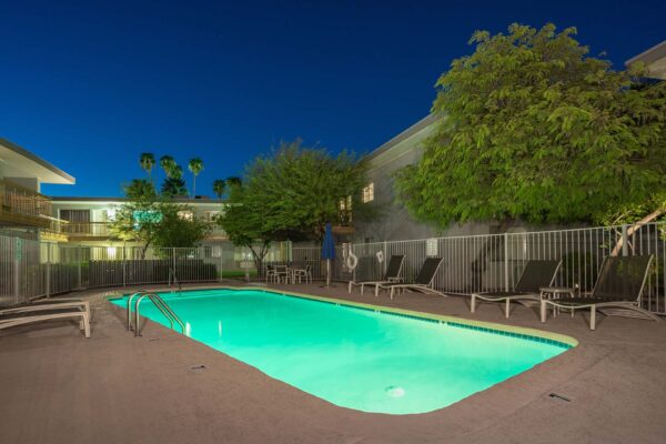 Aura at Midtown apartments pool area with lounge chairs and metal fence.