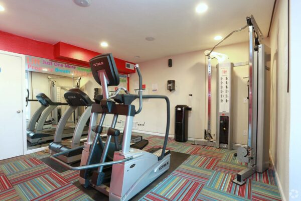 Aura at Midtown apartments fitness center with cardio machines and weight equipment.