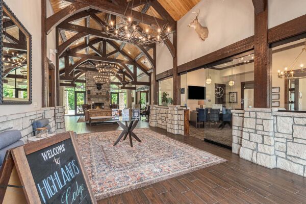 Highlands Lodge apartments lobby with wood style tile floor, large pattern rug, and elegant leasing office.