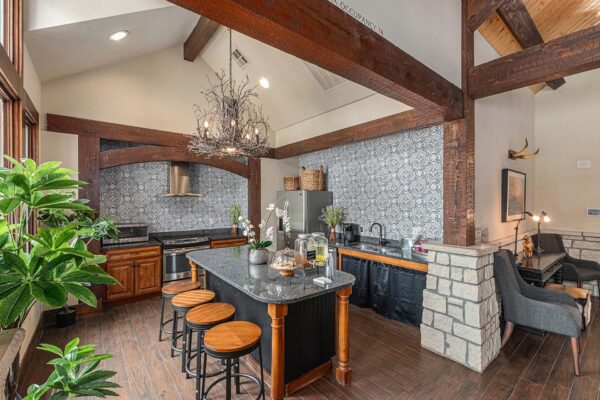 Highlands Lodge apartments community kitchen with wood cabinets, stone counters, and stainless steel appliances.