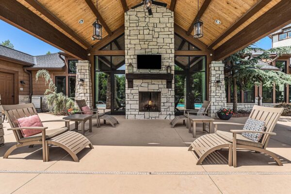 Highlands Lodge apartments covered patio with lounge chairs, fireplace, and TV.