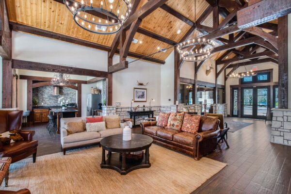 Highlands Lodge apartments clubhouse with wood style floor, plush couches, and rustic architecture.