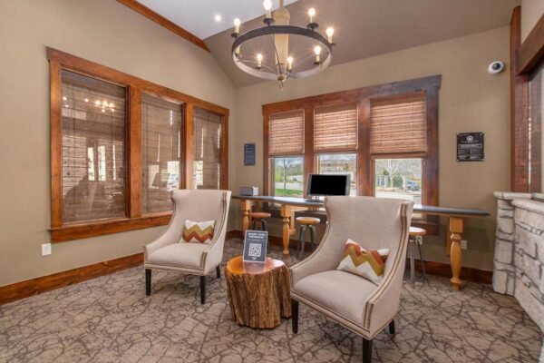 Highlands Lodge apartments leasing office with pattern carpets, plush chairs, and computer table.