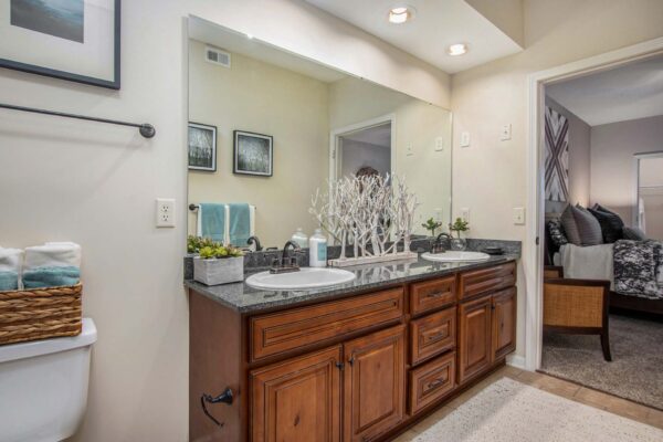 Highlands Lodge apartment bathroom with tile floor, wood cabinets, and stone counters.