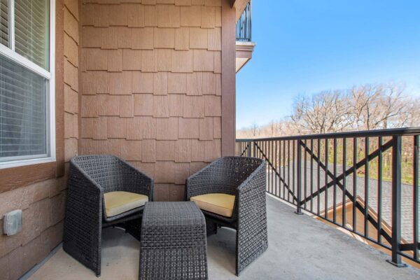 Highlands Lodge apartment balcony with outdoor furniture and metal railing.